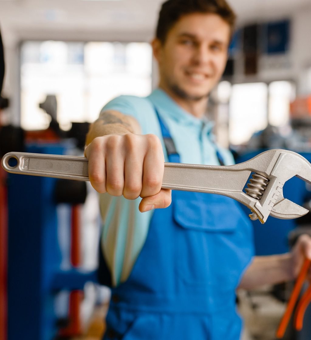 Plumber shows pipe wrenches at the showcase in plumbering store. Man buying sanitary engineering tools and equipment in shop
